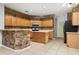 Kitchen with wood cabinets, center island, tile flooring, brick accents, and modern appliances at 8231 Sw 79Th Ct, Ocala, FL 34476