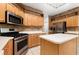 Kitchen with stainless steel appliances, light wooden cabinets, and tiled backsplash at 8231 Sw 79Th Ct, Ocala, FL 34476