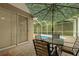 Outdoor patio with table and chairs, shaded by an umbrella, adjacent to the screened-in pool area at 8231 Sw 79Th Ct, Ocala, FL 34476