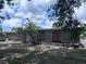 View of brick house backyard featuring brick detail and a well-manicured lawn at 891 S Atmore Cir, Deltona, FL 32725
