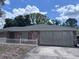 Exterior view of a brick house with a well manicured lawn and white picket fence at 891 S Atmore Cir, Deltona, FL 32725
