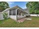 Back exterior featuring screened porch, vinyl fence, and brick patio area at 941 Village Lake N Dr, Deland, FL 32724