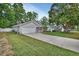 Single-story home with attached garage and a long driveway on a lush green lot at 941 Village Lake N Dr, Deland, FL 32724