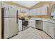 Spacious kitchen features white cabinets, stainless steel appliances, tiled floors, and ample counter space at 941 Village Lake N Dr, Deland, FL 32724