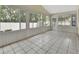 Enclosed sunroom with tile flooring, surrounded by windows and access to the backyard at 941 Village Lake N Dr, Deland, FL 32724