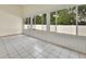 Sunroom with tile flooring and large windows offering views of the lush backyard at 941 Village Lake N Dr, Deland, FL 32724