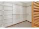 Functional walk-in closet with shelving, carpeting, and a door with wooden slats at 941 Village Lake N Dr, Deland, FL 32724