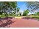 Community basketball court with shade trees and secure fencing around the play area at 979 Leyburn Dr, Deltona, FL 32725