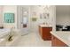 Bright bathroom featuring a soaking tub, white tile floors, and a vanity with a mirror at 979 Leyburn Dr, Deltona, FL 32725