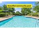Beautiful community pool surrounded by mature landscaping, lounge chairs, and umbrella seating area at 979 Leyburn Dr, Deltona, FL 32725