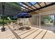 Community lounge area with tables, chairs, sun umbrellas, and sun shelter in a securely fenced area at 979 Leyburn Dr, Deltona, FL 32725