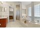 Elegant main bathroom with a garden tub, columns, tile floors, and a separate shower stall at 979 Leyburn Dr, Deltona, FL 32725