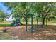 Community playground with swings, slide, bench seating, and mature trees at 979 Leyburn Dr, Deltona, FL 32725