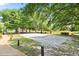 Sand volleyball court surrounded by mature trees and a paved walkway at 979 Leyburn Dr, Deltona, FL 32725