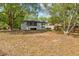 Backyard view of house and large yard with mature trees at 706 W Franklin Ave, Deland, FL 32720