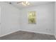 Bright bedroom with gray carpet, fresh white paint and a window overlooking backyard at 706 W Franklin Ave, Deland, FL 32720