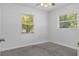 Bright bedroom with gray carpet, fresh white paint and dual windows overlooking backyard at 706 W Franklin Ave, Deland, FL 32720