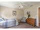 Neutral bedroom with ceiling fan, framed art and chair, illuminated by natural light at 10 Foxhunter Flt, Ormond Beach, FL 32174