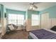 Light-filled bedroom with mint-green walls, wainscoting, and modern gray chair at 10 Foxhunter Flt, Ormond Beach, FL 32174