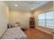 Bright bedroom featuring hardwood floors, large window, and daybed with decorative pillows at 10 Foxhunter Flt, Ormond Beach, FL 32174
