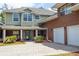 Two-story home with light green and brick exterior, manicured lawn, and two-car garage at 10 Foxhunter Flt, Ormond Beach, FL 32174