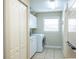 Spacious laundry area with storage cabinets, modern washer and dryer, and a whiteboard at 10 Foxhunter Flt, Ormond Beach, FL 32174
