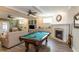 A living room featuring a pool table, fireplace, built-in shelving, and a comfortable seating area, perfect for entertaining at 10 Foxhunter Flt, Ormond Beach, FL 32174