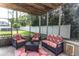Inviting screened porch with wicker furniture, patterned rug, offering views of the backyard at 10 Foxhunter Flt, Ormond Beach, FL 32174