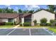 Exterior of the property featuring mature landscaping, well-kept lawn, and parking spaces at 101 Grand Plaza Dr # G30, Orange City, FL 32763
