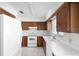 Well-lit kitchen features white appliances, wooden cabinets, and a functional layout for cooking and food preparation at 101 Grand Plaza Dr # G30, Orange City, FL 32763
