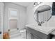 Modern bathroom with a sleek vanity, round mirror, shiplap accents, and hexagon tile floors at 1020 Hornbeam St, Oviedo, FL 32765