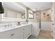 Elegant bathroom features a dual sink vanity, lighted mirror, and a glass-enclosed shower at 1020 Hornbeam St, Oviedo, FL 32765