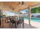Outdoor patio with dining and seating areas overlooks a sparkling pool and fenced backyard at 1020 Hornbeam St, Oviedo, FL 32765