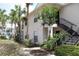Exterior view of condo building featuring lush landscaping, palm trees, and a community pool in the background at 1083 S Hiawassee Rd # 611, Orlando, FL 32835