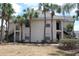 Exterior view of a two-story condo building with palm trees, dark stairs, and grass in the front yard at 1083 S Hiawassee Rd # 611, Orlando, FL 32835