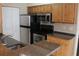 Kitchen featuring stainless steel appliances, granite counters, and wood cabinets at 1083 S Hiawassee Rd # 611, Orlando, FL 32835