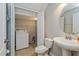 Compact bathroom with convenient laundry closet, pedestal sink, and tiled floor at 109 Bel Fiore Cv, Sanford, FL 32773