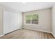 Bedroom with laminate flooring, closet, and a window overlooking trees at 109 Bel Fiore Cv, Sanford, FL 32773