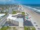 Aerial view displaying a condo complex near a beach, road, and local cityscape at 1233 N Atlantic Ave # 3090, Daytona Beach, FL 32118