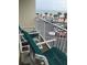 Balcony featuring outdoor seating overlooking a parking area with an ocean view and palm trees in the background at 1233 N Atlantic Ave # 3090, Daytona Beach, FL 32118