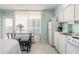 Bright kitchen area featuring white appliances, a dining table, and a beautiful ocean view through large windows at 1233 N Atlantic Ave # 3090, Daytona Beach, FL 32118