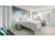 Bright, updated bedroom with a queen bed, palm tree wall art, and views of the ocean at 1233 N Atlantic Ave # 3090, Daytona Beach, FL 32118