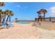 Outdoor swimming pool surrounded by tables, chairs, and palm trees at 1233 N Atlantic Ave # 3090, Daytona Beach, FL 32118