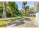 Spacious backyard featuring mature trees, lush green grass, and a large patio area at 128 Oakridge Ave, Edgewater, FL 32132