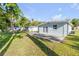 Exterior view of the home featuring a patio, spacious backyard, and lush green grass at 128 Oakridge Ave, Edgewater, FL 32132