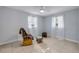 Light-filled bedroom with tile floors, a rocking chair, and two windows with sheer curtains at 128 Oakridge Ave, Edgewater, FL 32132