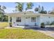 Charming one-story home featuring a well-manicured lawn and cozy front porch at 128 Oakridge Ave, Edgewater, FL 32132