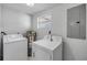 Functional laundry room featuring a washer, dryer, water heater, and utility panel at 128 Oakridge Ave, Edgewater, FL 32132