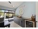 Bar area with wine fridge, modern cabinets and sliding glass doors leading to screened patio and backyard at 1446 Stone Trl, Enterprise, FL 32725
