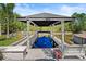 The property has a private boat dock with a boat lift and a seating area surrounded by tropical foliage at 1446 Stone Trl, Enterprise, FL 32725